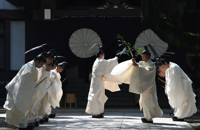 Yasukuni Shrine priests purify themselves before walking towards the outer shrine to perform a Shinto ritual during the three- day spring festival at the shrine in Tokyo on April 22, 2018. (Photo by Toshifumi Kitamura/AFP Photo)