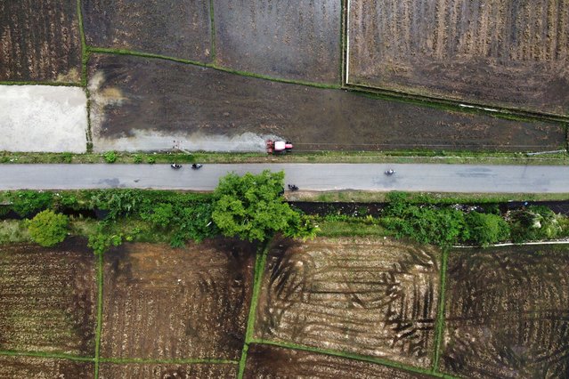A picture taken by a drone shows a farmer plowing a rice field with a tractor at the start of the planting season in Aceh Besar, Aceh, Indonesia, 24 October 2025. (Photo by Hotli Simanjuntak/EPA)
