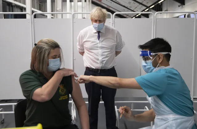 Britain's Prime Minister Boris Johnson watches first responder Caroline Cook receiving an injection of a Covid-19 vaccine at Ashton Gate Stadium in Bristol, England, Monday January 11, 2021. The center is one of the seven mass vaccination centers now opened to the general public as the government continues to ramp up the vaccination programme against Covid-19. (Photo by Eddie Mulholland/Pool via AP Photo)