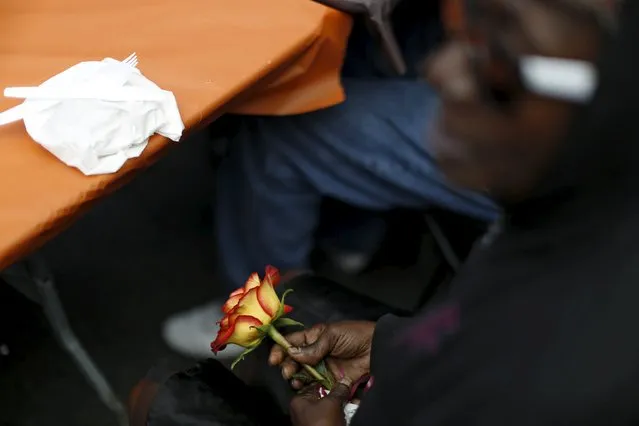 A person holds a rose while waiting for an early Thanksgiving meal served to the homeless at the Los Angeles Mission in Los Angeles, California, November 25, 2015. (Photo by Mario Anzuoni/Reuters)
