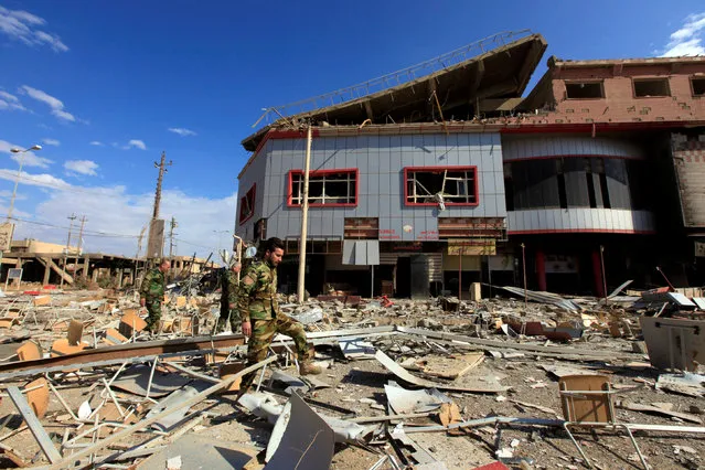 Iraqi Christian soldiers walk near a bulding destroyed by Islamic State militants, in Qaraqosh, near Mosul, during an operation to attack Islamic State militants in Mosul, Iraq, November 2, 2016. (Photo by Alaa Al-Marjani/Reuters)