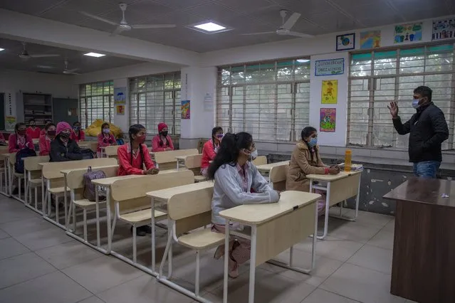 Students wearing face masks as a precaution against the coronavirus, attend classes as schools reopen after being closed for months due to the COVID-19 pandemic in New Delhi, India, Monday, January 18, 2021. Delhi on Monday opened schools for students of grade 10 and 12 after a gap of more than nine months. (Photo by Altaf Qadri/AP Photo)