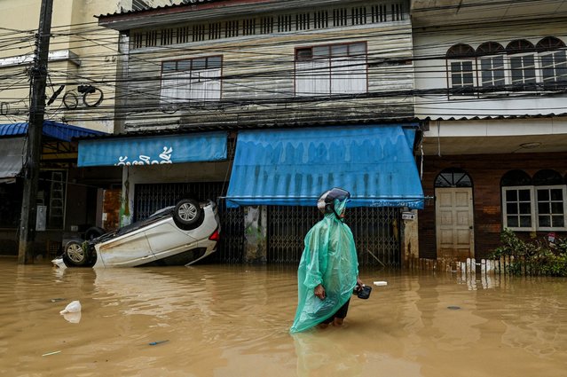A man stands in front of his partially submerged home with a car that was swept away by floods, on a flooded street in Hat Yai district, affected by deadly heavy rainfall, which has impacted several provinces in southern Thailand, in Songkhla province, Thailand, on November 26, 2025. (Photo by Karit Chaui-aksorn/Reuters)