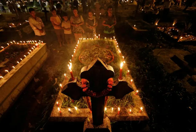 People pray in front of the grave of their relative after decorating it during the observance of All Souls Day in Kolkata, India November 2, 2016. (Photo by Rupak De Chowdhuri/Reuters)