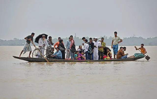 Flood affected villagers are transported in a boat to a safer place in Hojai district, in Assam, June 17, 2018. (Photo by Anuwar Hazarika/Reuters)