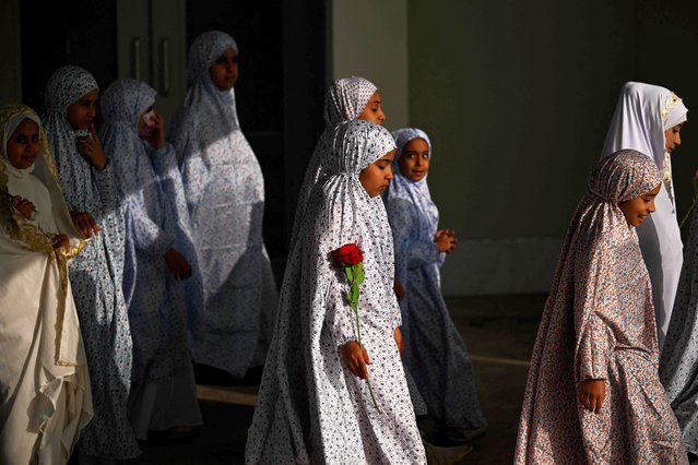 Young Iraqi girls who have reached the age of wearing a hijab, are clothed in the head covering worn by many Muslim women for the first time during a ceremony organised at the Basra International Stadium in Iraq's southern city of Basra on December 11, 2025. (Photo by Hussein Faleh/AFP Photo)