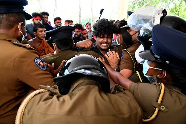Police officers scuffle with a medical student as he protests along with others against Sri Lanka's crippling economic crisis, outside the Health Ministry in Colombo on April 6, 2022. (Photo by Ishara S. Kodikara/AFP Photo)