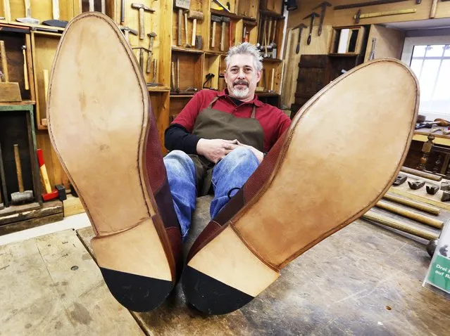 Shoemaker Juergen Dohn poses with shoes he made in 150 hours of work with the size of 75 (US 34) in Frankfurt, Germany, Thursday, November 10, 2016. Dohn claims the leather shoes are the largest wearable shoes in the world. (Photo by Michael Probst/AP Photo)