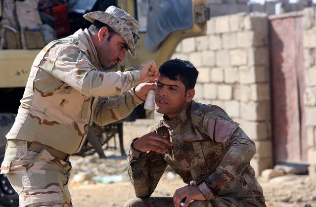 Iraqi soldiers shaves at Shahrezad village east of Mosul, Iraq November 11, 2016. (Photo by Ari Jalal/Reuters)