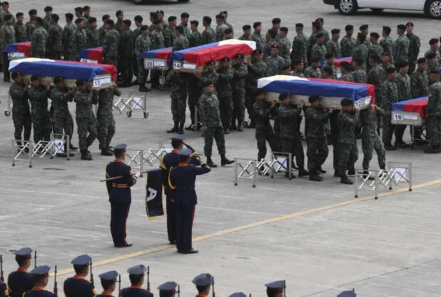 Members of the Philippine National Police's (PNP) Special Action Force (SAF) unit carry metal caskets containing the bodies of slain SAF police who were killed in Sunday's clash with Muslim rebels, upon arriving at Villamor Air Base in Pasay city, metro Manila January 29, 2015. (Photo by Romeo Ranoco/Reuters)