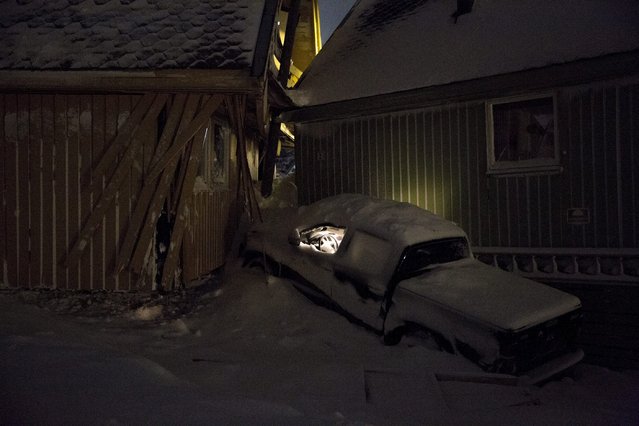 Lights are left on inside a car which was jammed between two houses pushed together by the force of Saturday's avalanche which hit the Norwegian town of Longyearbyen, the biggest settlement on the Arctic archipelago of Svalbard, roughly midway between the North Pole and the northernmost tip of Europe, December 20, 2015. (Photo by Tore Meek/Reuters/NTB Scanpix)