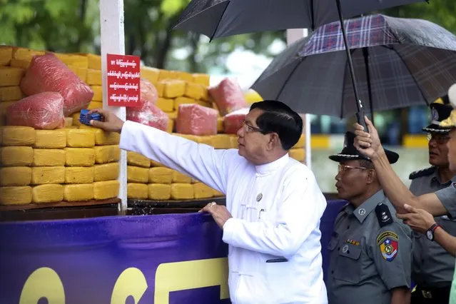 Soe Thein, Yangon region chief minister, inspects seized illegal narcotics displayed during a destruction ceremony to mark International Day against Drug Abuse and Illicit Trafficking on the outskirts of Yangon, Myanmar, Monday, June 26, 2023. (Photo by Thein Zaw/AP Photo)