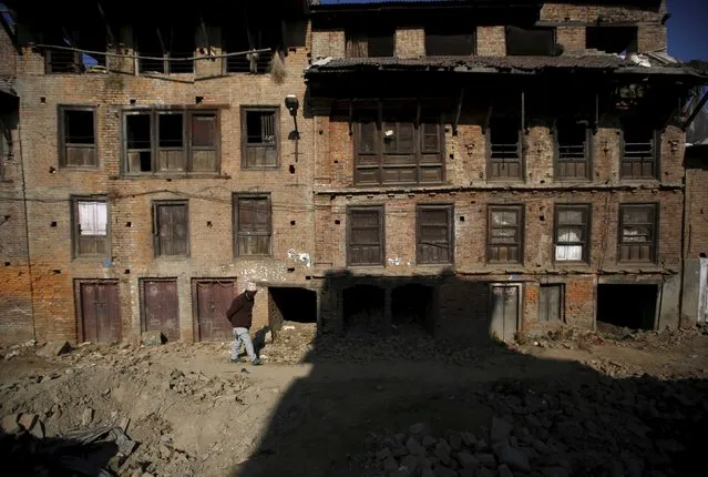 A man walks past abandoned houses damaged during the earthquake earlier this year, in Bhaktapur, Nepal December 28, 2015. (Photo by Navesh Chitrakar/Reuters)