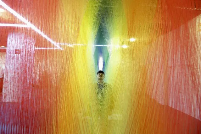 A man looks at a installation made of sock textiles on display at a demonstration hall of the local sock-making industry in Zhuji, Zhejiang province February 2, 2015. European and Chinese factories slashed prices in January as production flatlined, heightening global deflation risks that point to another wave of central bank stimulus in the coming year. (Photo by Reuters/Stringer)