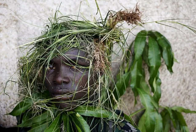 A protester wears grass around his face to obscure his identity during a protest against President Pierre Nkurunziza's decision to run for a third term, in Bujumbura, Burundi, May 11, 2015. (Photo by Goran Tomasevic/Reuters)