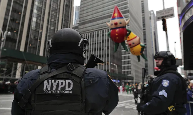 New York Police counterterrorism personnel watch as the Macy's Thanksgiving Day parade makes its way down Sixth Avenue, Thursday, November 24, 2016, in New York. (Photo by Julie Jacobson/AP Photo)