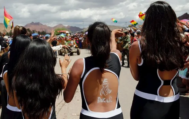 A woman with a Dakar Rally logo painted on her back cheers as she welcomes Honda quad rider Walter Nosiglia (C, back) of Bolivia during the seventh stage in the Dakar Rally 2016 in Tupiza, Bolivia, January 9, 2016. (Photo by Marcos Brindicci/Reuters)