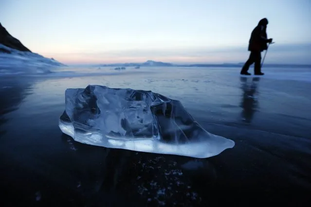 A fisherman walks on the frozen surface of the Yenisei River while checking ice holes near the village of Anash, Novosyolovsky District of Krasnoyarsk region, Russia February 7, 2015. (Photo by Ilya Naymushin/Reuters)