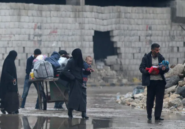 Civilians carry their belongings as they flee deeper into the remaining rebel-held areas of Aleppo, Syria December 7, 2016. (Photo by Abdalrhman Ismail/Reuters)