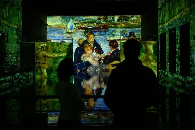 Journalists watch projections of paintings during a press visit of the digital exhibition entitled “Monet, Renoir, and Chagall: Journeys Around the Mediterranean” at the “Bassin des Lumieres” in a former German WWII submarine base in Bordeaux, on May 11, 2021, ahead of the reopening of cultural spaces scheduled for May 19 after a closure aimed at curbing the spread of the Covid-19 pandemic. (Photo by Philippe Lopez/AFP Photo)