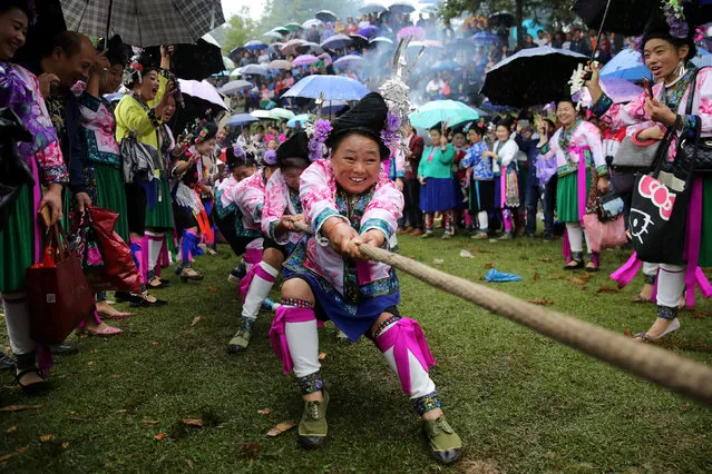 Ethnic Miao women in traditional costumes take part in a tug of war to celebrate a local festival at a village in Rongshui Miao Autonomous County, Guangxi Zhuang Autonomous Region, China September 27, 2018. (Photo by Reuters/China Stringer Network)