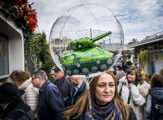 A woman carries a children's balloon with a tank inside during an autumn festival held in central Moscow, Russia on October 7, 2018. (Photo by Mladen Antonov/AFP Photo)