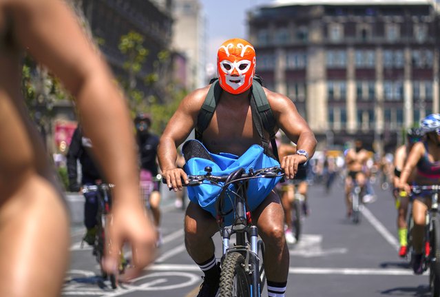 Naked cyclists wearing masks, ride through the streets of Mexico City during the World Naked Bike Ride day, Saturday, June 11, 2022. (Photo by Eduardo Verdugo/AP Photo)