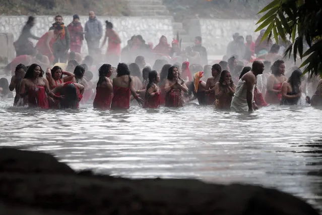 Nepalese Hindu women take holy dips at the Salinadi River on the first day of  month long Swasthani Bratakatha festival, in Sankhu, outskirts of Katmandu, Nepal, Sunday, January 24, 2016. During this festival, devotees recite holy scriptures dedicated to Hindu goddess Swasthani and Lord Shiva. Unmarried women pray to get a good husband while those married pray for the longevity of their husbands by observing a month-long fast. (Photo by Niranjan Shrestha/AP Photo)