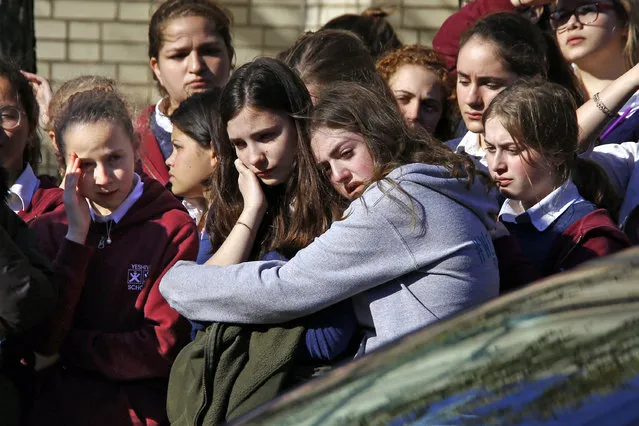 Students from the Yeshiva School in the Squirrel Hill neighborhood of Pittsburgh stand outside Beth Shalom Synagogue after attending the funeral service for Joyce Fienberg, Wednesday, October 31, 2018. Fienberg, 75, Melvin Wax, 87, and Irving Younger, 69, were to be laid to rest as part of a weeklong series of services for the 11 people killed in a shooting rampage at the Tree of Life synagogue Saturday. (Photo by Gene J. Puskar/AP Photo)