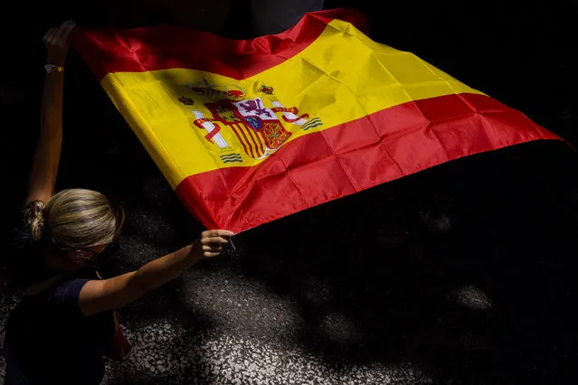 A woman holds the Spanish flag during a protest against the Spanish government's plan to issue pardons to a dozen imprisoned Catalan separatist leaders, Madrid, Sunday, 13 June, 2021. The demonstration has been organized by a civil society group in defense of the nation's unity that chose to hold it at a central square that has become popular for far-right political rallies. (Photo by Bernat Armangue/AP Photo)