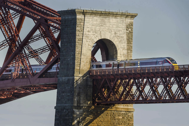 In this May 6, 2021 file photo, a LNER Azuma train crossing the Forth Bridge in Edinburgh. Britain plans to bring the national rail network back under government control, reversing one of the most controversial elements of the privatization drive carried out by the Conservative governments of the 1980s and ’90s. Under plans announced Thursday, May 20, 2021, the government will create a new entity known as Great British Railways that will own all railroad infrastructure, set most fares and schedules, collect ticket revenue and run a single ticketing website. Private companies will continue to operate trains under contracts with the state. (Photo by Euan Cherry/PA Wire via AP Photo/File)