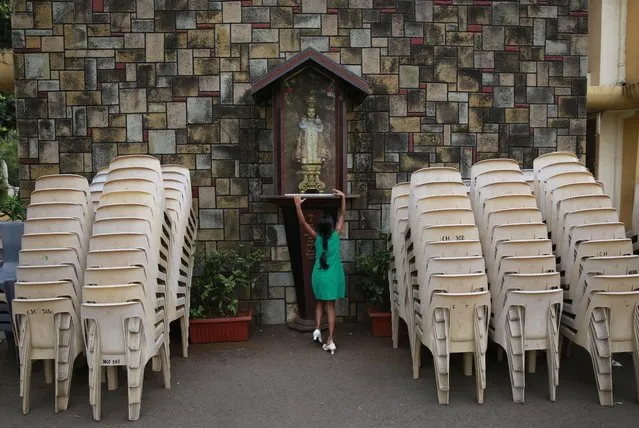 An Indian Christian girl tries to touch a statute of Jesus baby for blessings during Easter mass at a Church in Mumbai, India, Sunday, April 5, 2015. (Photo by Rafiq Maqbool/AP Photo)