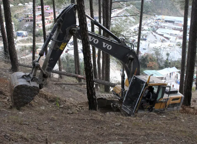 An earth-mover makes a vertical drill on the top of a mountain where a tunnel that collapsed in Uttarakhand state, India, Saturday, November 18, 2023. Forty workers were trapped in the collapsed road tunnel in northern India for a seventh day Saturday as rescuers waited for a new machine to drill through the rubble so they could crawl to their freedom. (Photo by AP Photo)