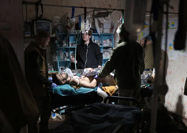 Ukrainian military medics treat a wounded Ukrainian serviceman at a stabilisation point near Bakhmut, Donetsk region, on November 14, 2023, amid the Russian invasion of Ukraine. (Photo by Anatolii Stepanov/AFP Photo)