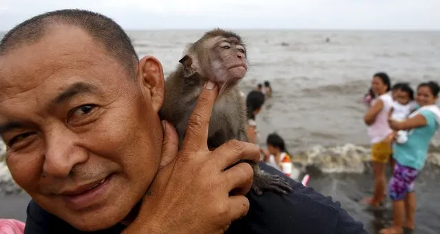 A resident plays with his five-month-old pet monkey named “Momoy” at a beach during Easter Sunday celebrations in Tanza, Cavite south of Manila April 5, 2015. (Photo by Erik De Castro/Reuters)