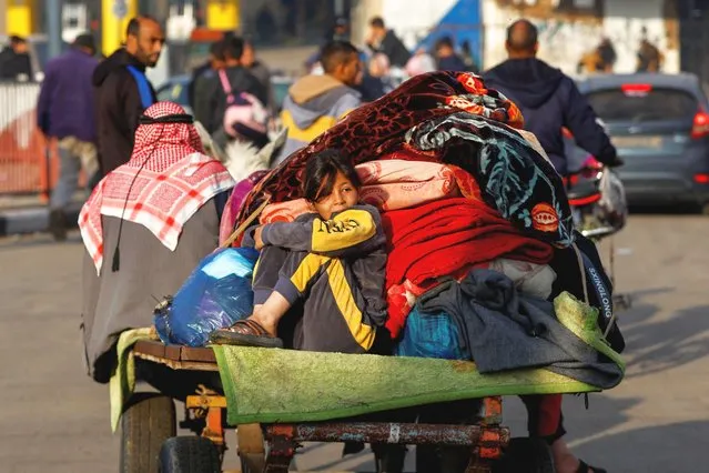 A child sits on a trailer, as Palestinians flee their houses due to Israeli strikes, after a temporary truce between Hamas and Israel expired, in the eastern part of Khan Younis in the southern Gaza Strip on December 1, 2023. (Photo by braheem Abu Mustafa/Reuters)