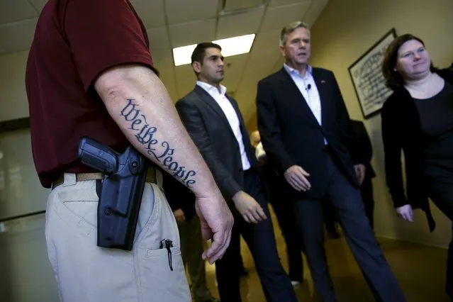 U.S. Republican presidential candidate Jeb Bush (2nd R) walks past a security guard with a sidearm and a tattoo of the start of the preamble to the U.S. constitution, “We the people”, after a town hall meeting with employees at FN America gun manufacturers in Columbia, South Carolina February 16, 2016. (Photo by Jonathan Ernst/Reuters)