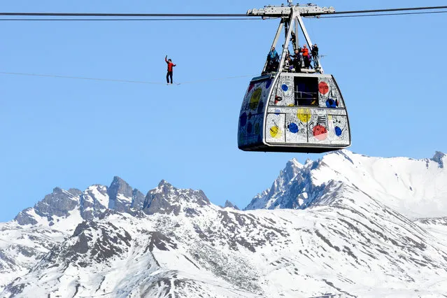 French highliner Julien Millot performs on the Paradiski cable way, 380m high, designed by French creator Jean-Charles de Castelbajac, on December 16, 2013 in front of the Mont Blanc mountain in La Plagne. (Photo by Jean-Pierre Clatot/AFP Photo)