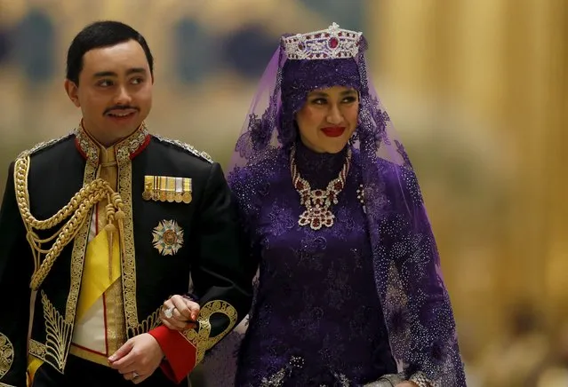 Brunei's newly wed royal couple, Prince Abdul Malik and Dayangku Raabi'atul 'Adawiyyah Pengiran Haji Bolkiah, leave the royal wedding banquet at the Nurul Iman Palace in Bandar Seri Begawan April 12, 2015. (Photo by Olivia Harris/Reuters)