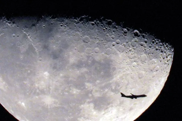 A commercial airline aircraft flies past the rising waxing gibbous moon above Kuwait City on December 3, 2023. (Photo by Yasser Al-Zayyat/AFP Photo)
