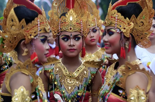 Balinese girls in traditional costumes gather during a parade for this year's last sundown in Bali island, Indonesia on New Year's Eve, Tuesday, December 31, 2013. (Photo by Firdia Lisnawati/AP Photo)