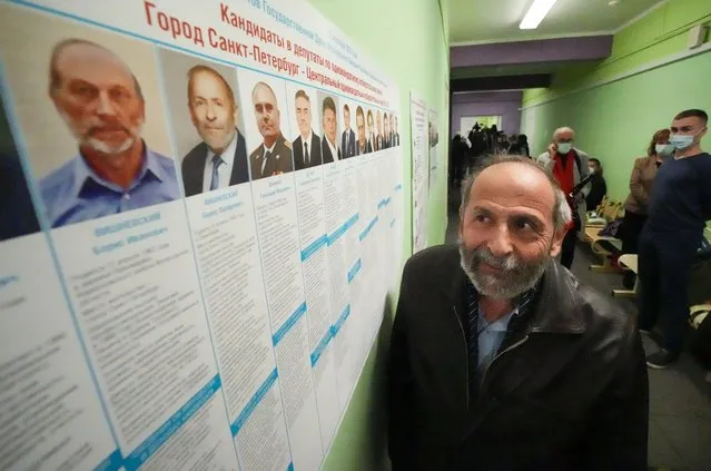 Boris Vishnevsky of the Yabloko party who is running for both the State Duma and the regional legislature looks at a candidates list at a polling station in St. Petersburg, Russia, Sunday, September 19, 2021. Vishnevsky discovered that there are two other men running in both races under the same name as him. One of his opponents is from the ruling United Russia party, according to the newspaper Novaya Gazeta. (Photo by Dmitri Lovetsky/AP Photo)