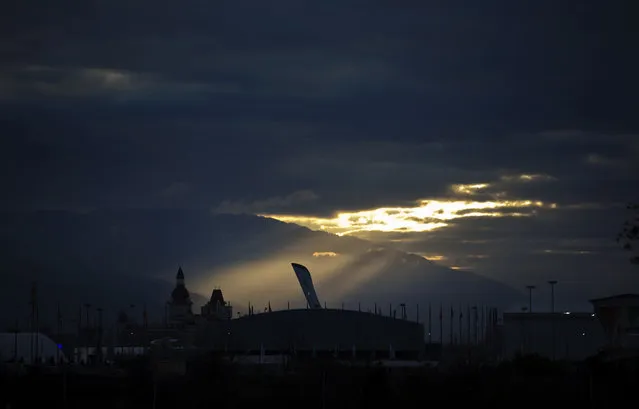 The sun rises over the Olympic cauldron in the Olympic Park at the 2014 Winter Olympics, Wednesday, February 5, 2014, in Sochi, Russia. (Photo by David Goldman/AP Photo)