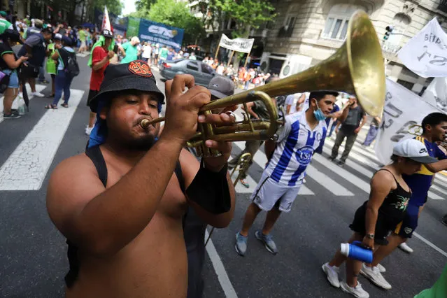 A demonstrator plays a trumpet as members of labor unions march to the National Congress to demand a national budget free from IMF restrictions, in Buenos Aires, Argentina, October 28, 2021. (Photo by Matias Baglietto/Reuters)