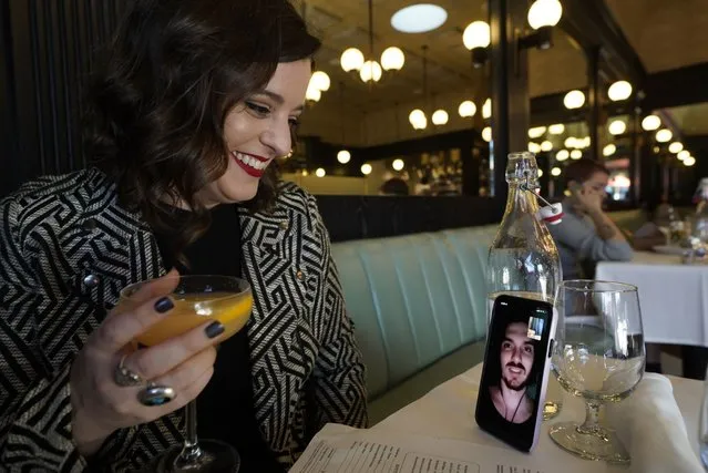 Erin Tridle holds a video chat with her boyfriend Jordan Commarrieu living in Paris from their favorite French restaurant “Petit Trois” in Los Angeles on Friday, November 5, 2021. Travel restrictions that have separated couples and relatives living in different countries are about to end. New rules go into effect Monday, Nov. 8 that allow air travel from previously restricted countries as long as the traveler has proof of vaccination and a negative COVID-19 test. (Photo by Damian Dovarganes/AP Photo)