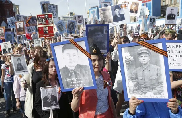 People take part in Immortal Regiment march with pictures of World War Two soldiers on Red Square during the Victory Day celebrations in Moscow, Russia, May 9, 2015. (Photo by Maxim Shemetov/Reuters)