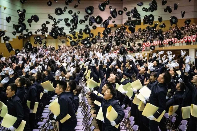 Graduates of the National Defence Academy of Japan toss their caps in the air during their graduation ceremony in Yokosuka, Kanagawa prefecture on March 23, 2024. (Photo by Yuichi Yamazaki/AFP Photo)