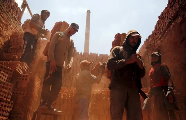 Labourers work at a traditional bricks factory in Arab Mesad district of Helwan, northeast of Cairo, May 14, 2015. About 45 labourers are employed at the brick factory and most work 10 hours a day. Adult workers earn a daily wage of 70 Egyptian pounds ($9) and child workers earn 40 Egyptian pounds ($5). (Photo by Amr Abdallah Dalsh/Reuters)