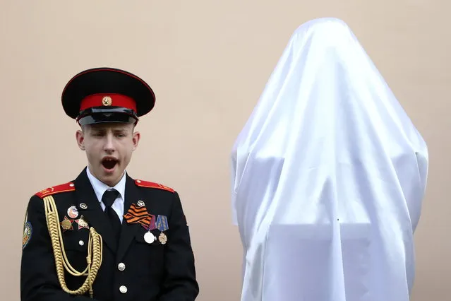 An honor guard yawns during a ceremony to unveil a monument to renowned Russian crooner turned Kremlin-loyal lawmaker Iosif Kobzon in Moscow, Russia on May 21, 2019. Kobzon died in 2018 at the age of 80. (Photo by Stanislav Krasilnikov/TASS)