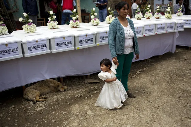 In this March 29, 2016 photo, villagers gather by coffins holding the remains of their loved ones slain more than two decades ago by Shining Path guerrillas, before burying them in Ccano, a village in the Huanta area of Ayachcuo department, Peru. While some Peruvians remember Alberto Fujimori as the man who ordered the army to drive a tank to shut down Congress in 1992, reorganized the country’s judiciary and sparked a constitutional crisis as a new constitution was drafted, those in rural areas like  Ccano remember him beating back the Maoist-inspired rebel group that slaughtered their parents and children during a brutal armed conflict. (Photo by Rodrigo Abd/AP Photo)